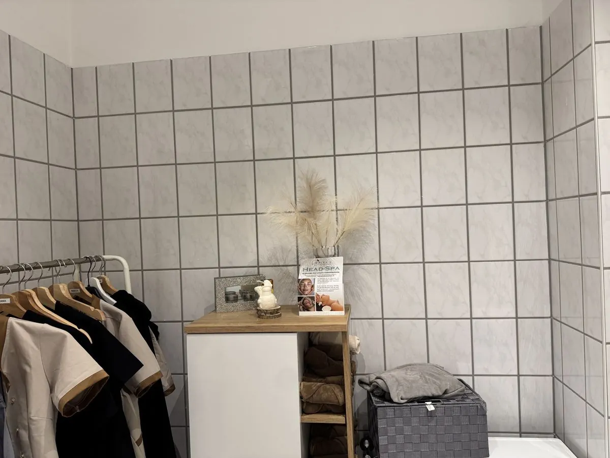 Foto des gefliesten Raums vorher mit Kleiderstange und Regal